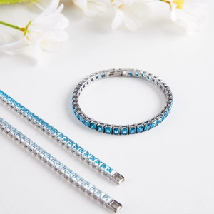 Nahaufnahme von silbernen Tennis-Armbändern mit blauen Zirkonia und Steckverschluss