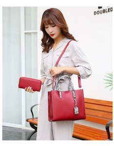 Detail of red crocodile embossed handbag and wallet set with snake print straps