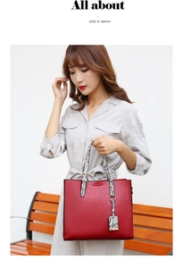 Detail of red crocodile pattern tote bag with snake skin handles held by a model
