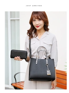 Detail view of black crocodile pattern tote bag and matching long zipper wallet set
