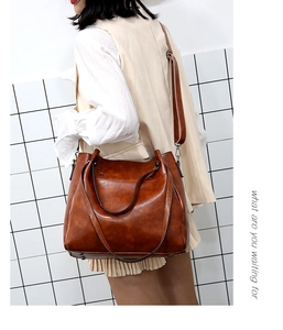 Bolso tote marrón vintage con correa de hombro y detalles de ganchos metálicos
