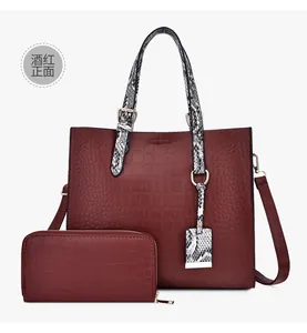 Detail of burgundy crocodile embossed tote bag and matching long zipper wallet set