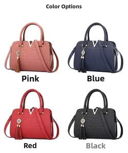 Detail view of crocodile textured handbags in pink, navy, red and black with V-shaped logo
