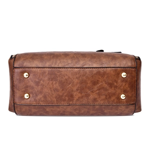Bottom view of vintage brown leather tote bag with protective gold metal rivets