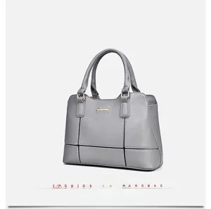 Detail view of grey lychee leather handbag showing cross-stitching and gold logo