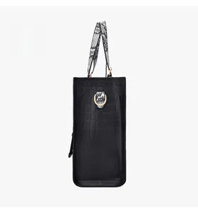 Close-up of black embossed crocodile pattern handbag with snakeskin texture handle