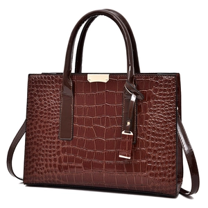 Sac à main marron à motif crocodile avec boucle dorée et poignée au design structuré