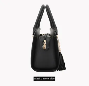 Side view of black lychee grain faux leather handbag with golden zipper and fringe tassel