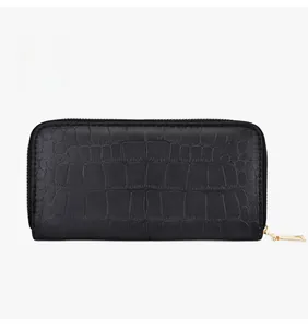 Detailed macro view of black crocodile pattern leather wallet with gold metal zipper closure