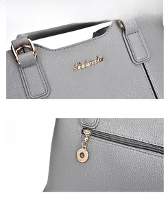 Close-up of litchi grain grey leather handbag showing gold logo and precise stitching
