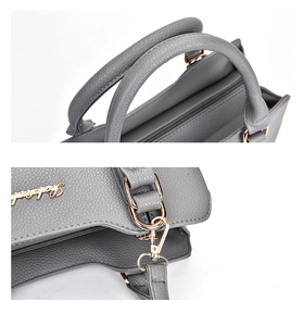 Detail view of grey litchi grain leather tote featuring gold metal hardware and stitching