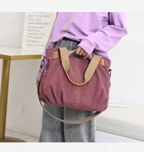 Canvas handbag with cream handles and adjustable shoulder strap shown in a lifestyle view