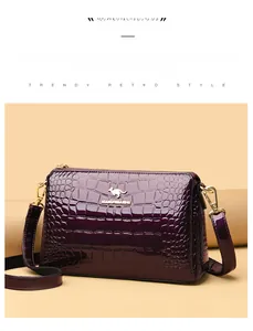 Detailed view of purple patent leather handbag featuring gold kangaroo logo and croc pattern