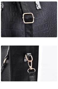 Close-up of black crocodile embossed leather texture with golden hardware and strap
