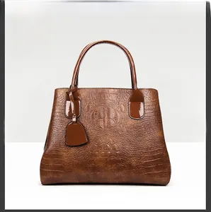 Macro view of brown crocodile texture leather and glossy tote handle detail