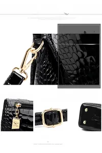 Detailed shot of golden hardware and kangaroo zipper on black crocodile leather bag