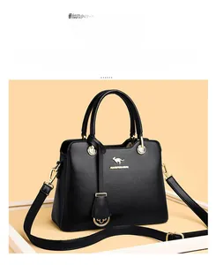 Details einer schwarzen Handtasche aus Leder mit Narbung und goldfarbenen Metallelementen