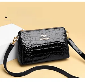 Macro detail of black crocodile pattern patent leather bag with golden kangaroo emblem