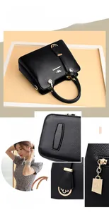 Detailaufnahme der schwarzen Lederhandtasche mit Narbenstruktur und goldenen Beschlägen