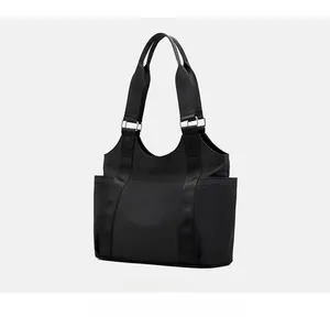Side view of large black oxford fabric tote bag featuring side pockets and silver buckles