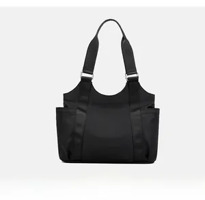 Back view of minimalist black oxford tote bag with wide woven straps and side pockets