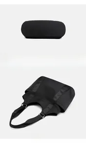 Detail of waterproof nylon tote bag showing wide shoulder strap and side pocket design