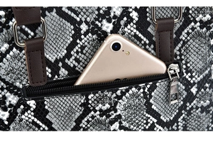 Detail view of back zipper pocket on snakeskin textured handbag showing phone storage