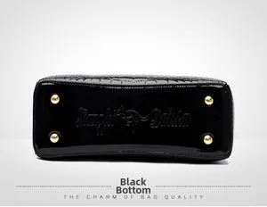 Detailed macro view of black patent leather bag bottom with gold studs and croc texture
