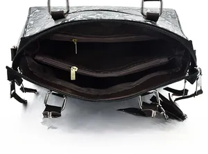 Detail view of the spacious inner compartments and dual zippers in a snake pattern bag