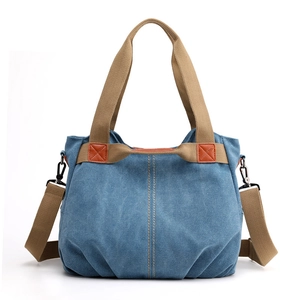 Blue canvas tote bag with orange leather patch and adjustable khaki shoulder strap