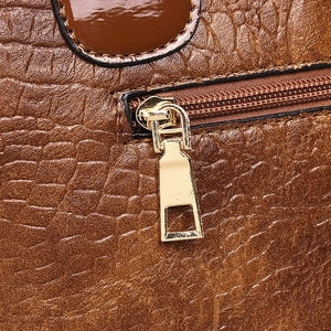 Brown crocodile embossed tote bag detail with golden metal zipper and smooth stitching