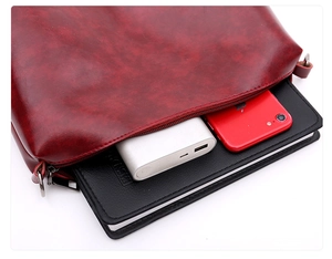 Detalle del interior de un bolso de cuero encerado rojo con espacio para accesorios