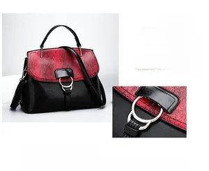 Détail du rabat en serpent rouge et boucle dorée sur un sac à main noir élégant