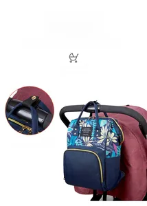 Detail of specialized stroller hooks on a navy floral backpack diaper bag for mothers