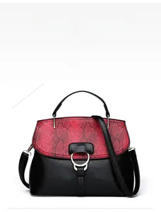 Détail du sac à main bicolore noir et rouge avec motif serpent et fermoir métallique