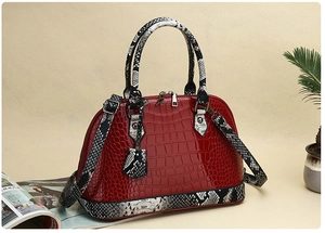 Detail of red crocodile embossed shell bag with snakeskin print handles and silver hardware