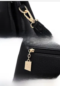 Detail der schwarzen Handtasche aus Leder mit goldenem Känguru-Logo und Reißverschluss