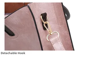 Detail of dusty pink leather bag featuring lychee texture and detachable gold hook