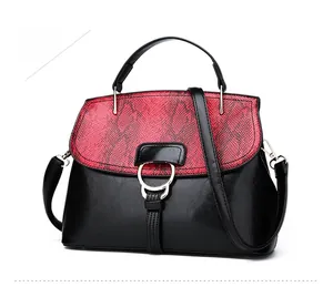 Détail du rabat en peau de serpent et boucle métallique sur sac bandoulière noir