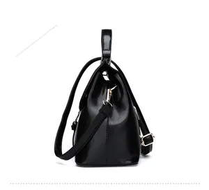 Détail du sac à main noir brillant en cuir serpent avec des crochets métalliques dorés