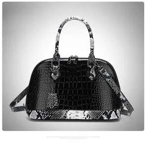 Detail of black crocodile-embossed shell bag with snake pattern handles and trim