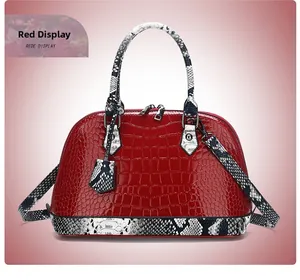Detail of red crocodile texture shell bag with snake skin pattern handles and silver zipper