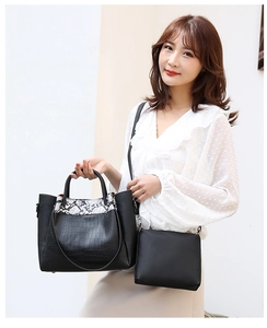 Close-up of black crocodile embossed bucket bag with snakeskin pattern stitching detail
