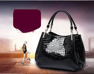 Detail of black crocodile pattern faux leather handbag with braided handles and metallic joints