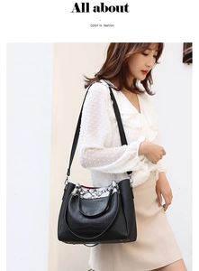 Detail of black crocodile texture bag with snakeskin accents and detachable strap