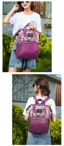 Detail of purple floral printed backpack showing large front pocket and side compartment