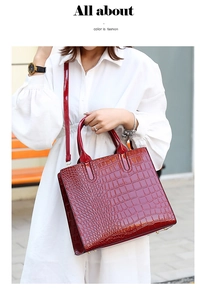 Close-up of wine red crocodile embossed tote bag with glossy finish and top handles