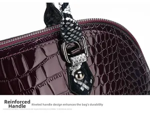 Detail of burgundy crocodile texture bag with snakeskin strap and silver rivet reinforcement