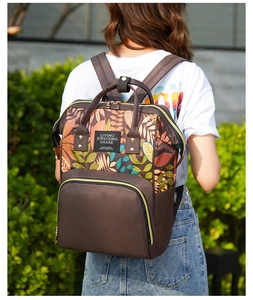Close-up of a large capacity diaper bag with autumn leaf pattern and durable top handles