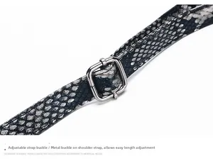 Detail view of crocodile pattern leather shoulder strap with adjustable silver metal buckle